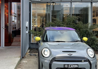 A mini cooper car is charging with an EV charger as installed by licensed electricians